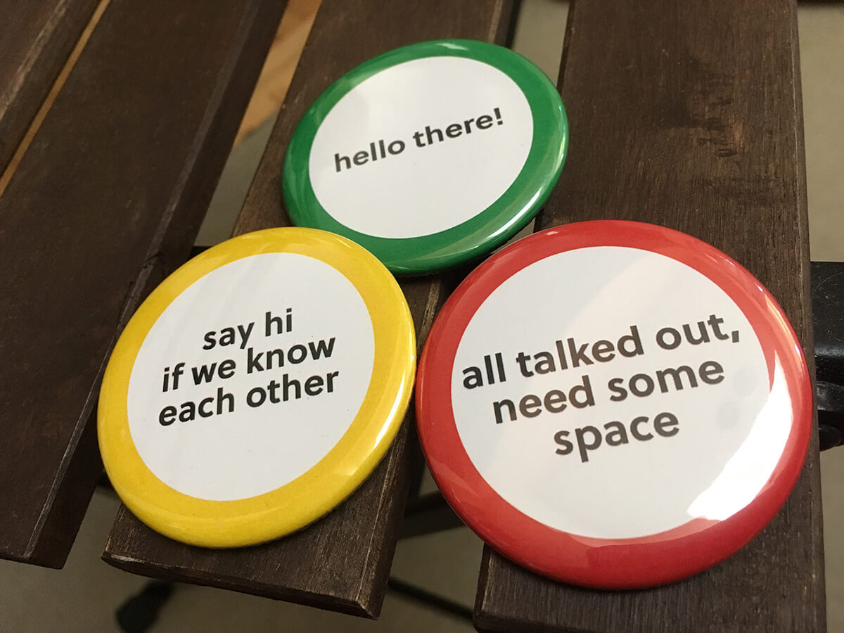 Paper bags pinned with a green button, yellow button, and red button