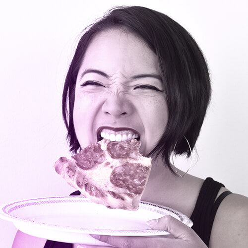 Photo of Danielle Leong biting a slice of pizza and holding a paper plate