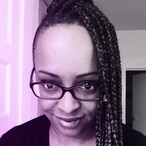 Photo of Imani Gandy with long braids, looking down at the camera
